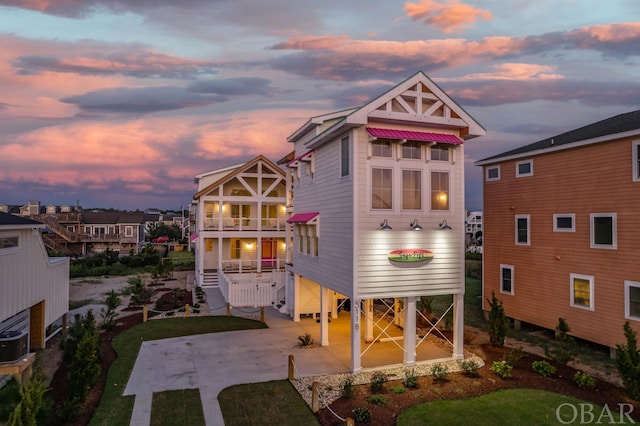 back of property with driveway, stairway, and a balcony