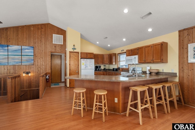 25270 Sea Isle Hills Dr Lot 5-18, Waves, NC 27982 - kitchen featuring wood walls, brown cabinets, white appliances, and visible vents