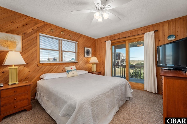 25270 Sea Isle Hills Dr Lot 5-18, Waves, NC 27982 - carpeted bedroom featuring a textured ceiling, wood walls, access to exterior, and ceiling fan
