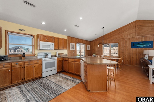 25270 Sea Isle Hills Dr Lot 5-18, Waves, NC 27982 - kitchen featuring visible vents, wood walls, a peninsula, white appliances, and light wood-style floors