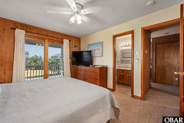 25270 Sea Isle Hills Dr Lot 5-18, Waves, NC 27982 - bedroom with a textured ceiling, wood walls, connected bathroom, access to outside, and light carpet