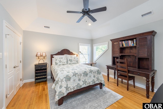 bedroom featuring lofted ceiling, light wood-type flooring, visible vents, and baseboards