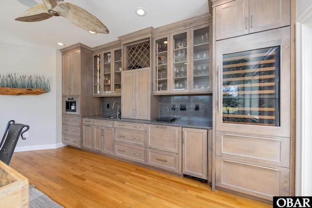 bar with ceiling fan, wine cooler, baseboards, light wood-type flooring, and decorative backsplash