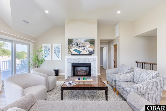 living room featuring a tile fireplace, recessed lighting, visible vents, baseboards, and light wood-type flooring