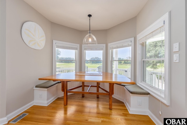 dining room featuring baseboards, breakfast area, visible vents, and light wood-style floors