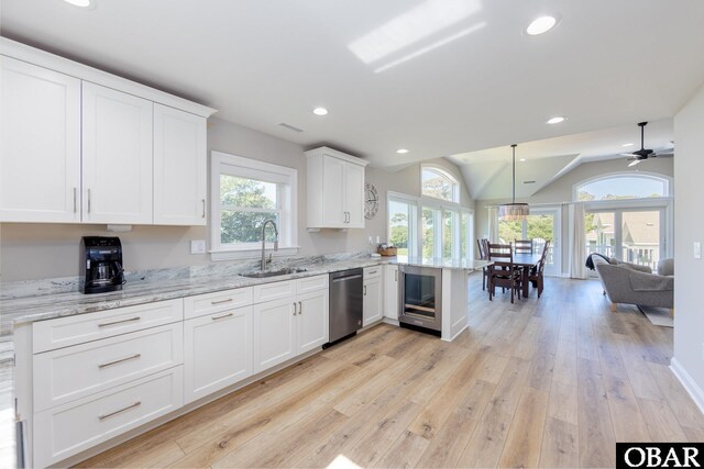 kitchen featuring recessed lighting, a peninsula, a sink, white cabinetry, and dishwasher