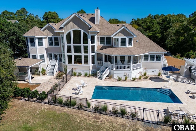 back of property with a fenced in pool, a chimney, stairway, fence, and a patio area