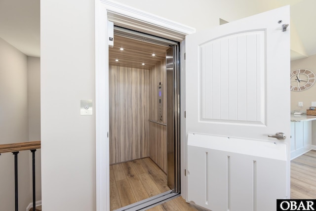 interior space with elevator and wood finished floors