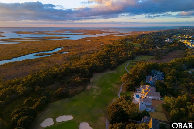 aerial view at dusk featuring a water view