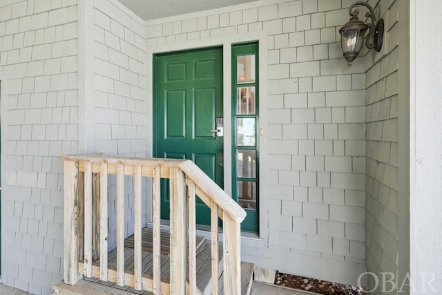 entrance to property with roof with shingles