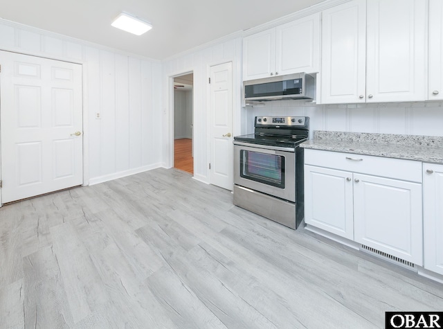 202 Winfall Blvd, Hertford, NC 27944 - kitchen featuring appliances with stainless steel finishes, white cabinets, light wood-style floors, light stone countertops, and crown molding