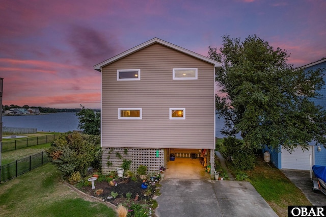 103 King Edward Ct Lot 13, Kill Devil Hills, NC 27948 - property exterior at dusk with driveway, a carport, and a water view