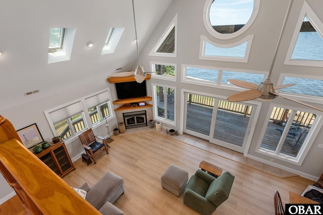 103 King Edward Ct Lot 13, Kill Devil Hills, NC 27948 - living area featuring a high ceiling, a fireplace with flush hearth, a skylight, wood finished floors, and ceiling fan