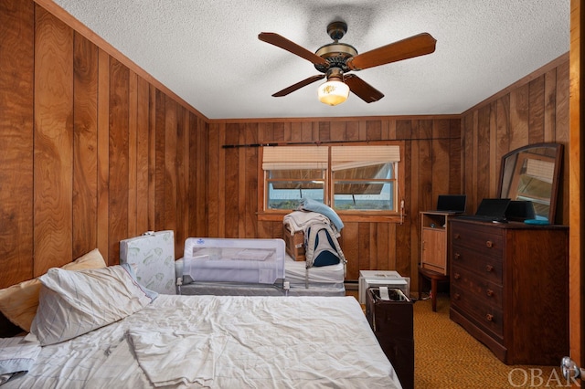 bedroom featuring a ceiling fan, carpet flooring, wooden walls, and a textured ceiling