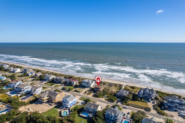 drone / aerial view featuring a water view, a residential view, and a view of the beach