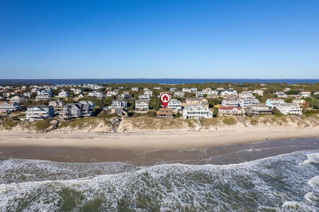 drone / aerial view with a beach view, a water view, and a residential view