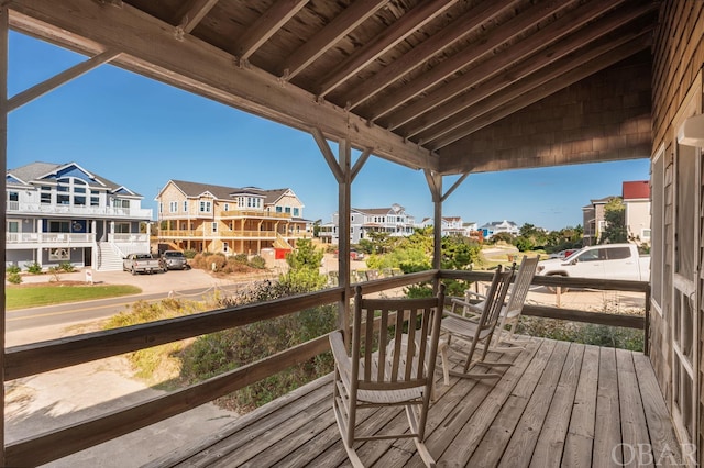 wooden terrace with a residential view and a porch