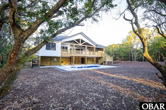 rear view of property featuring stairs, a patio area, fence, and a balcony