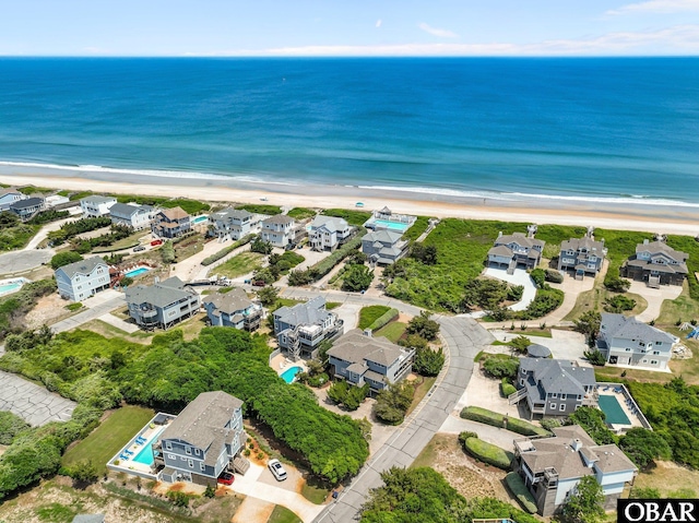 drone / aerial view with a beach view, a residential view, and a water view