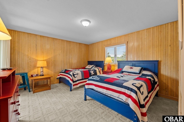 carpeted bedroom featuring wood walls