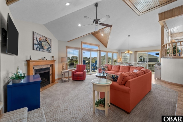 living area with lofted ceiling, a fireplace, baseboards, recessed lighting, and ceiling fan with notable chandelier