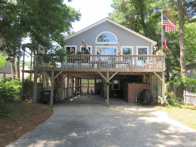 view of front of house with a deck, a carport, and concrete driveway