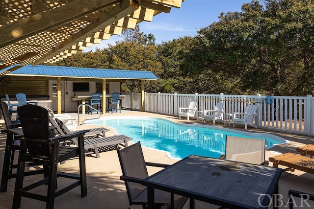 view of swimming pool with a fenced in pool, fence, a bar, and a patio