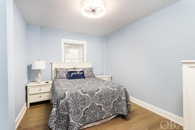 bedroom with dark wood finished floors and baseboards