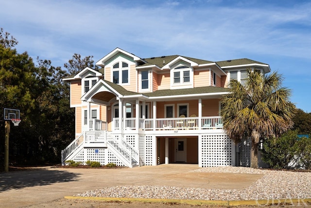 view of front facade with stairs, driveway, a porch, and an attached garage