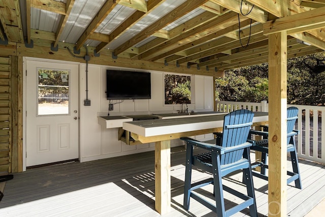 wooden deck featuring an outdoor bar and a sink