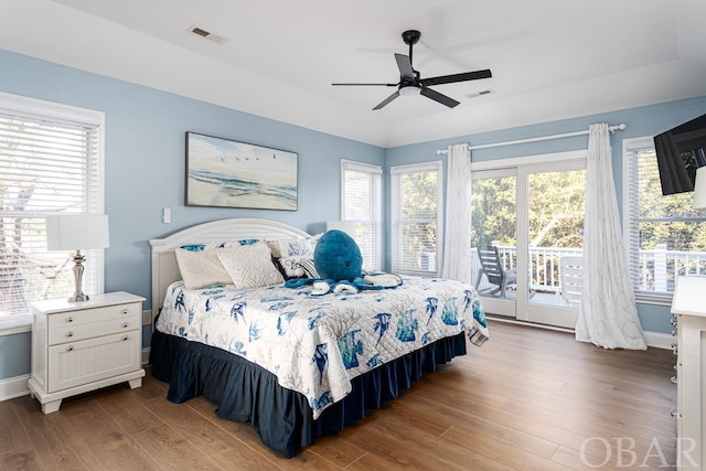 bedroom featuring access to outside, visible vents, and wood finished floors