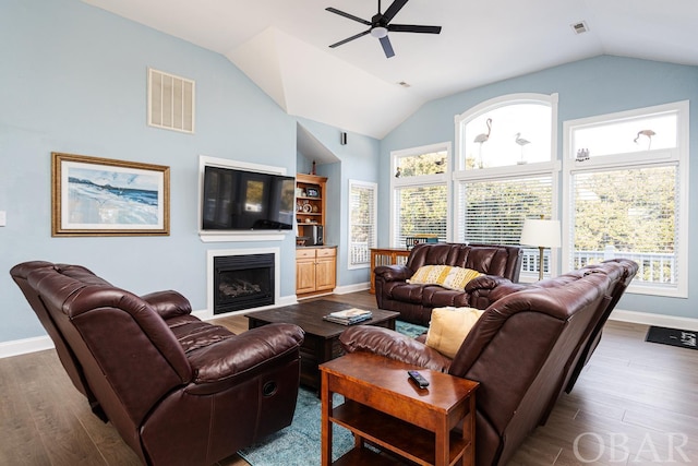 living area featuring a fireplace, visible vents, and wood finished floors