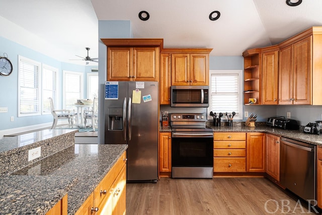 kitchen featuring stainless steel appliances, a healthy amount of sunlight, brown cabinets, and open shelves