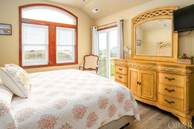 bedroom featuring visible vents, vaulted ceiling, and wood finished floors