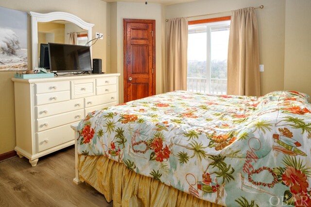 bedroom with wood finished floors and baseboards