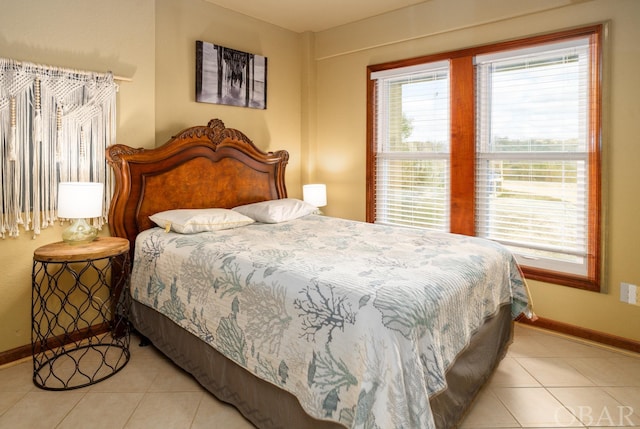 bedroom featuring light tile patterned flooring and baseboards