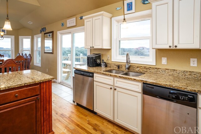 kitchen featuring dishwasher, hanging light fixtures, a sink, and lofted ceiling