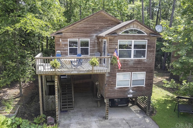 view of front facade featuring driveway, stairs, and a wooden deck