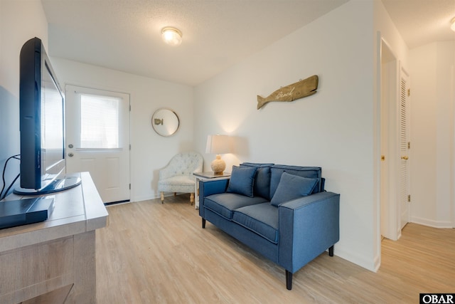 living area featuring light wood-type flooring and baseboards