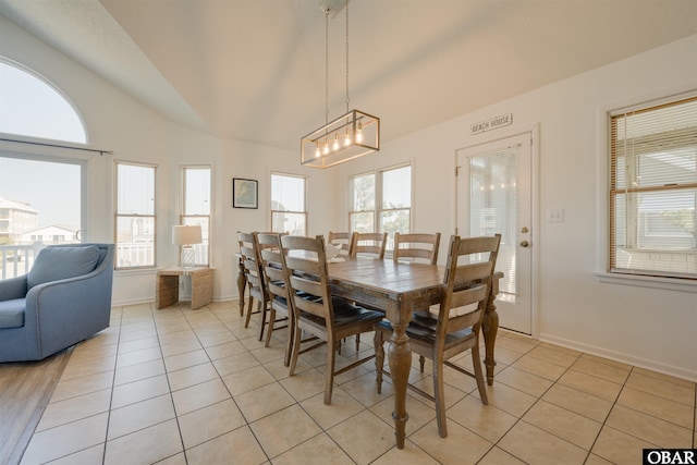 dining space featuring lofted ceiling, plenty of natural light, and light tile patterned floors