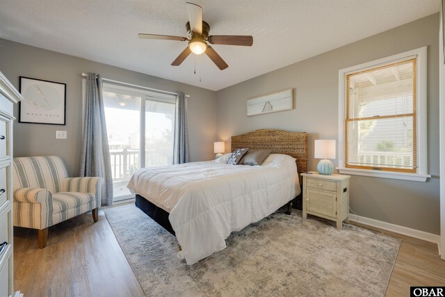 bedroom featuring light wood-style floors, ceiling fan, access to exterior, and baseboards