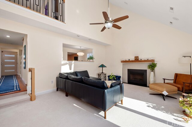 living area with carpet floors, a high ceiling, a fireplace, and baseboards