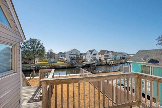 deck with a water view, a residential view, and a dock