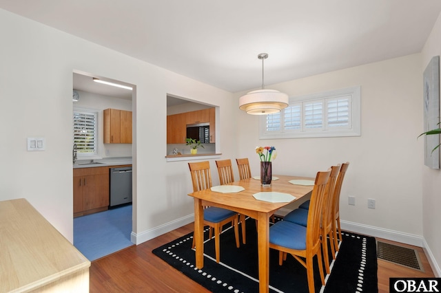 dining room with baseboards, visible vents, and light wood-style floors