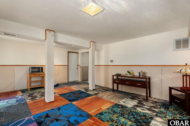 interior space featuring a wainscoted wall, wood finished floors, and visible vents