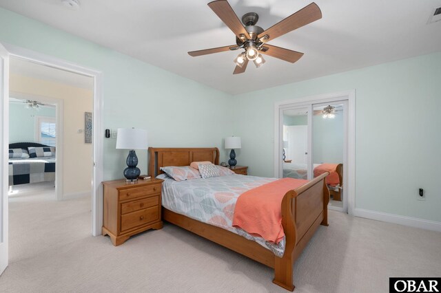 bedroom featuring connected bathroom, light colored carpet, ceiling fan, and baseboards