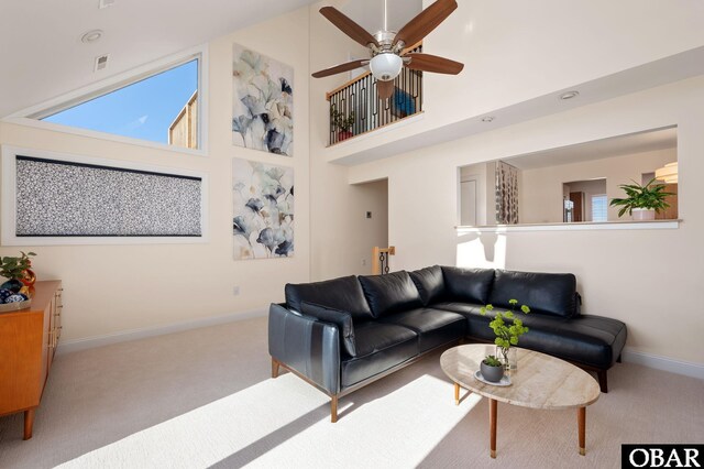 living room featuring visible vents, a towering ceiling, carpet flooring, ceiling fan, and baseboards