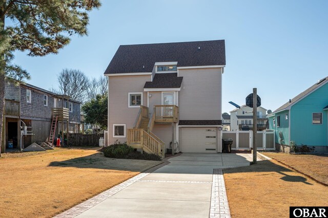 view of front of house featuring concrete driveway, a front yard, fence, and a residential view