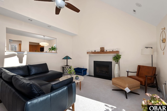 living area with high vaulted ceiling, a tiled fireplace, and light colored carpet