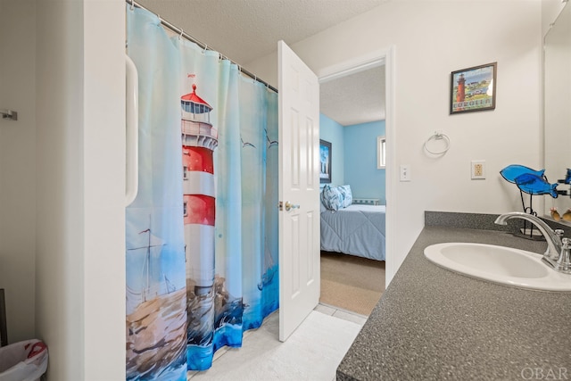 ensuite bathroom with a textured ceiling, curtained shower, connected bathroom, and vanity